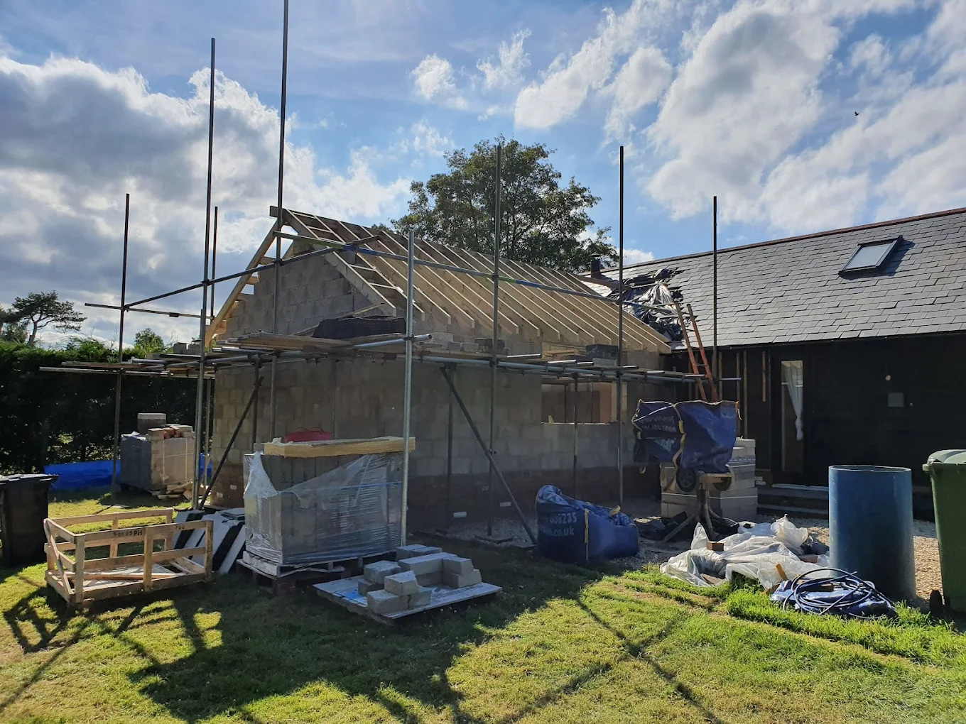 Barn extension under a newly built timber roof with scaffolding