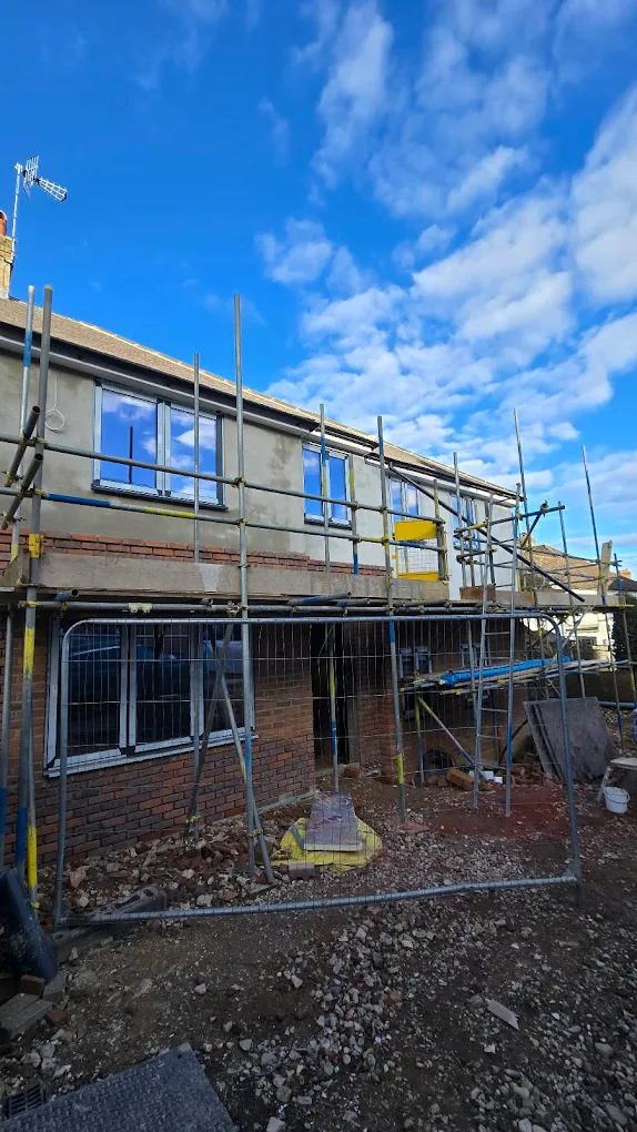 Two-storey house being rendered and insulated from scaffolding